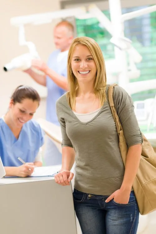 smiling woman at dental office counter